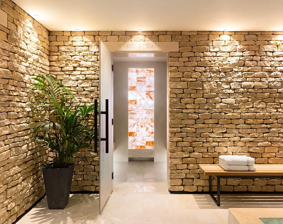 Himalayan salt steam room entrance within a spa designed by UK spa designers using natural stone and warm lighting